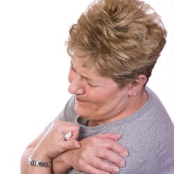 photo of woman holding shoulder in pain