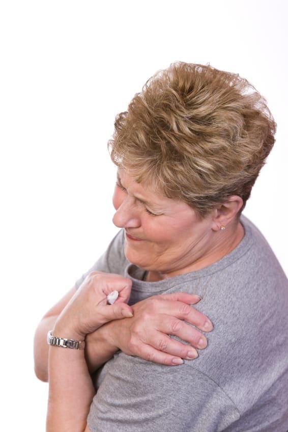 photo of woman holding shoulder in pain